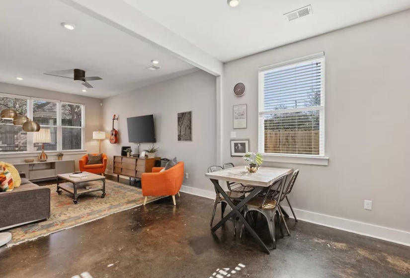 Open-concept common area featuring stained concrete flooring, recessed lighting, and a ceiling fan