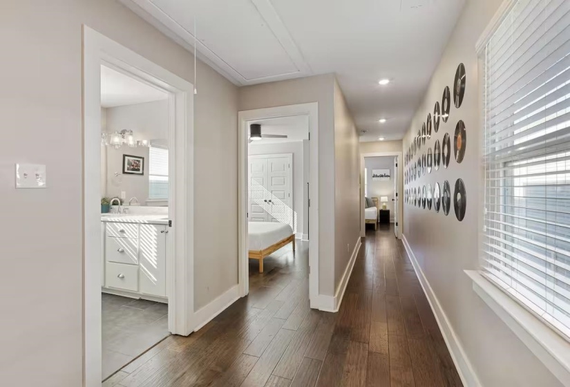 Hallway featuring wood-finish flooring, recessed lighting, and a window with blinds