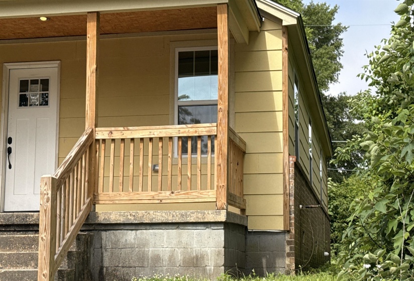 Front porch with natural wood railings and steps
