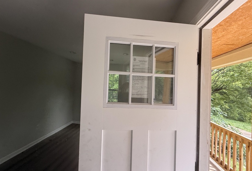 Entry door with upper window panes, dark wood-finish flooring, recessed lighting, and light-toned wall finishes