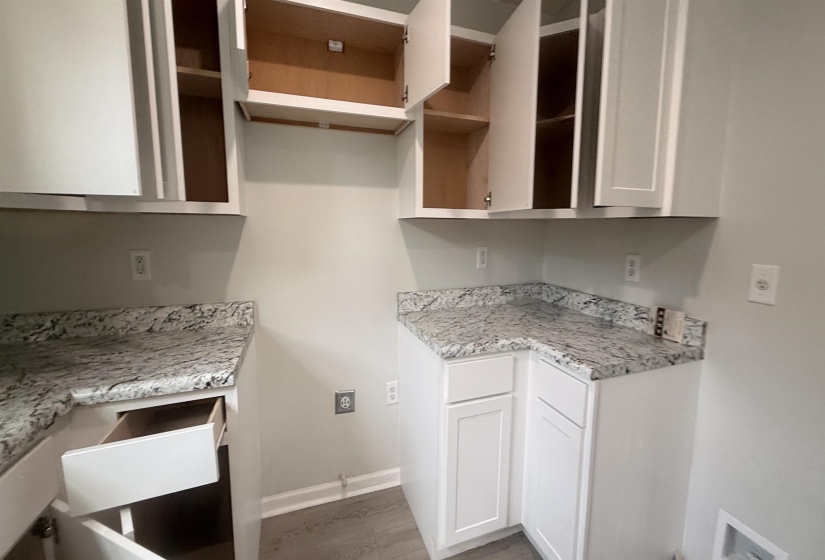 White shaker-style cabinetry with granite-finish countertops