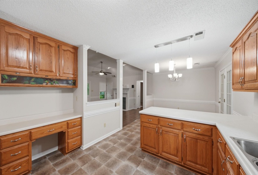 Kitchen featuring wood-finish cabinetry, desk area and vinyl flooring