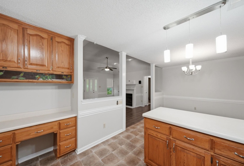 Kitchen area with wood cabinetry, light countertops, and vinyl flooring