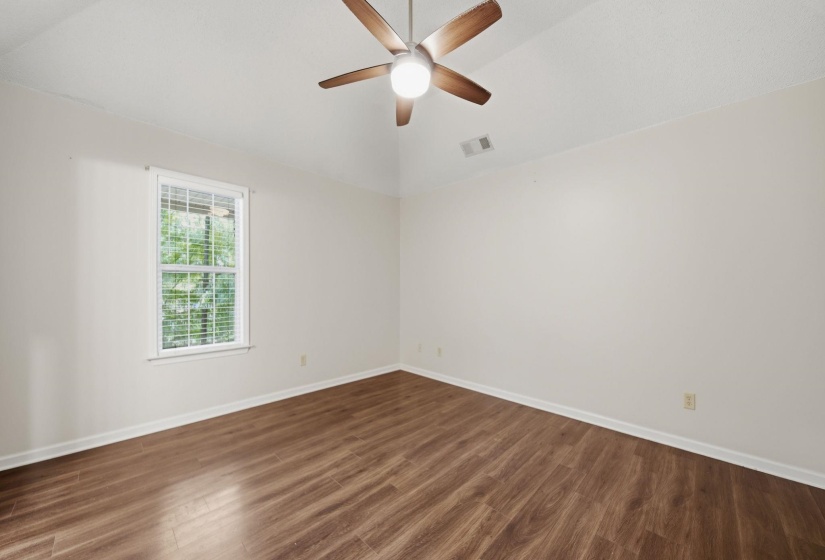 Primary Bedroom featuring wood-finish flooring, a single window with blinds, and an overhead ceiling fan with lighting