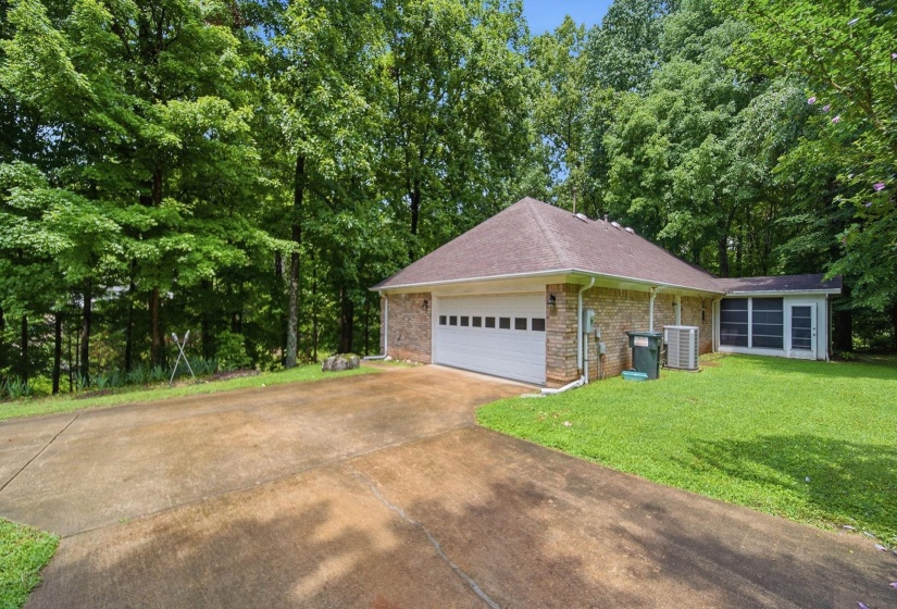 Exterior featuring a two-car garage, brick facade, and a screened porch