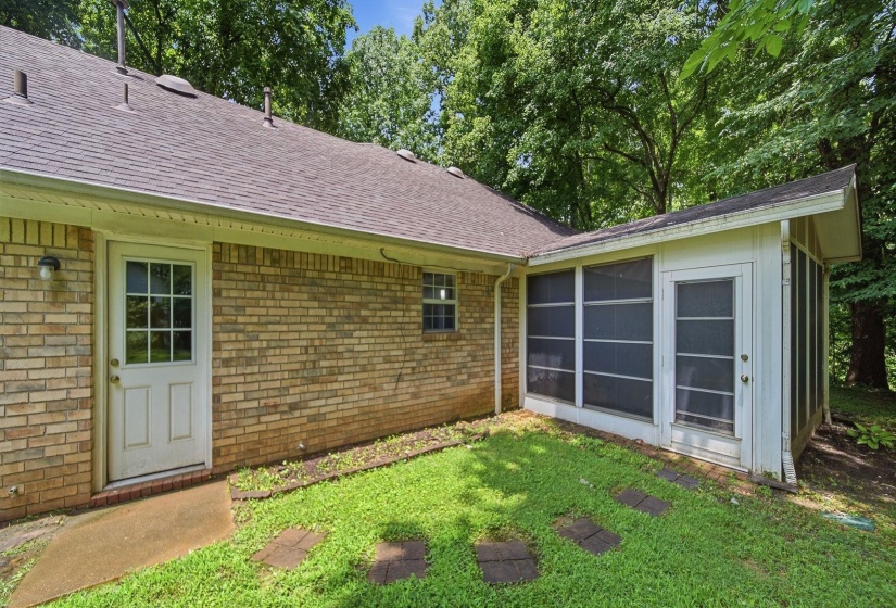 Brick exterior featuring a screened porch addition and an additional entry door