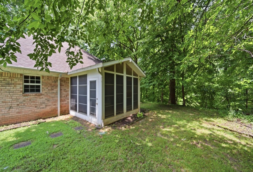 Screened porch extending from a brick exterior, featuring a gabled roofline and white trim
