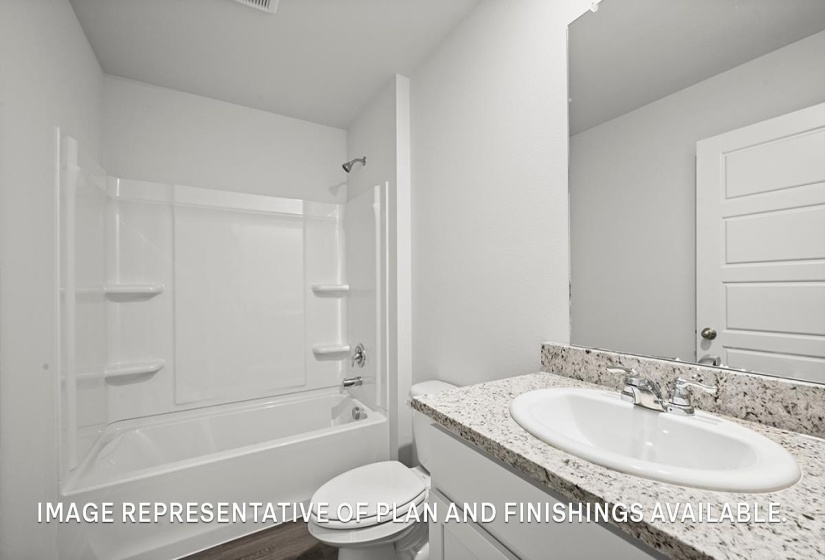 Bathroom featuring a white integrated tub and shower unit, a vanity with a light-colored speckled countertop, an oval undermount sink with a chrome faucet, and wood-finish flooring