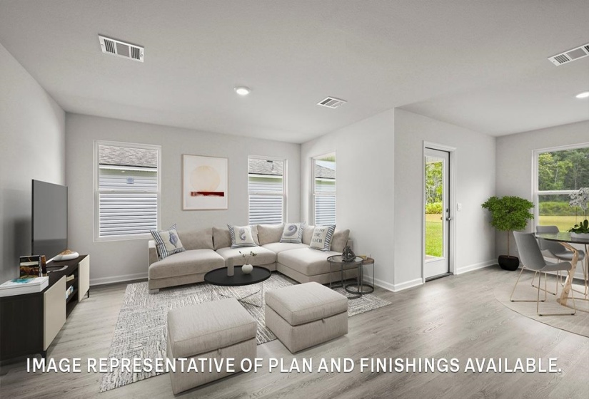 Open-concept living area featuring light wood-finish flooring, recessed lighting, and multiple windows with white blinds