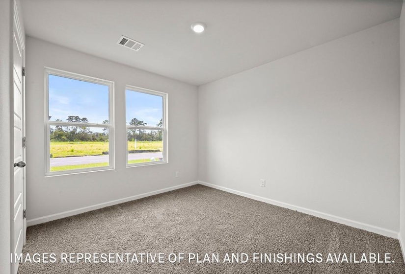 Bright interior space featuring two large windows, neutral-toned carpeting, white baseboards, and a recessed ceiling light