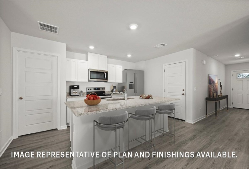 Open-concept kitchen featuring an island with stone-finish countertop, white cabinetry, stainless steel appliances, and wood-finish flooring