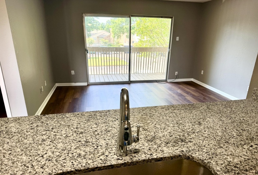 Kitchen countertop featuring a stainless steel sink with a modern faucet, offering an open concept to the living area