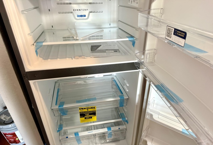 Integrated top-freezer refrigerator featuring multiple transparent shelves, clear door bins, and two bottom crisper drawers