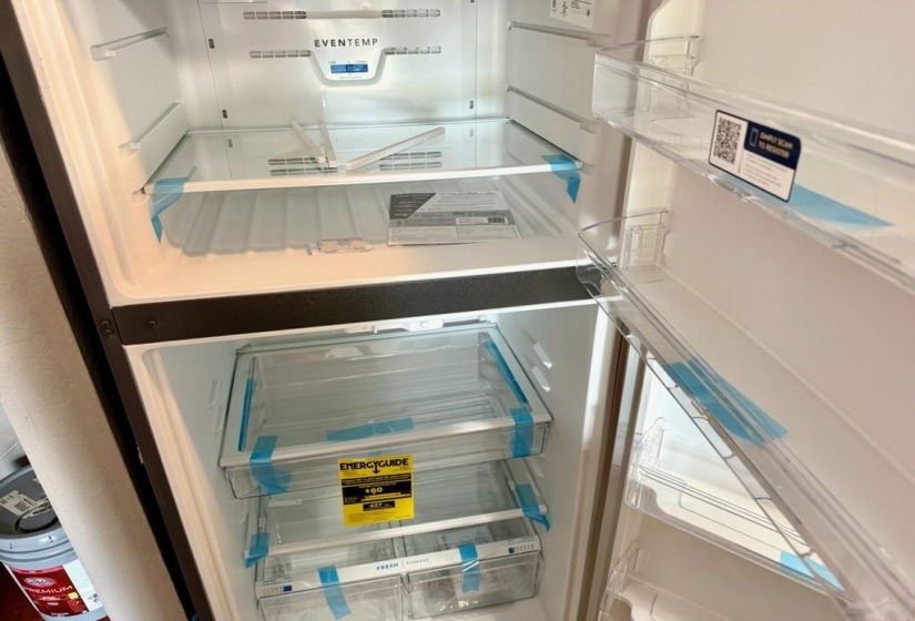Stainless steel top-freezer refrigerator featuring glass shelving, clear door bins, and bottom crisper drawers