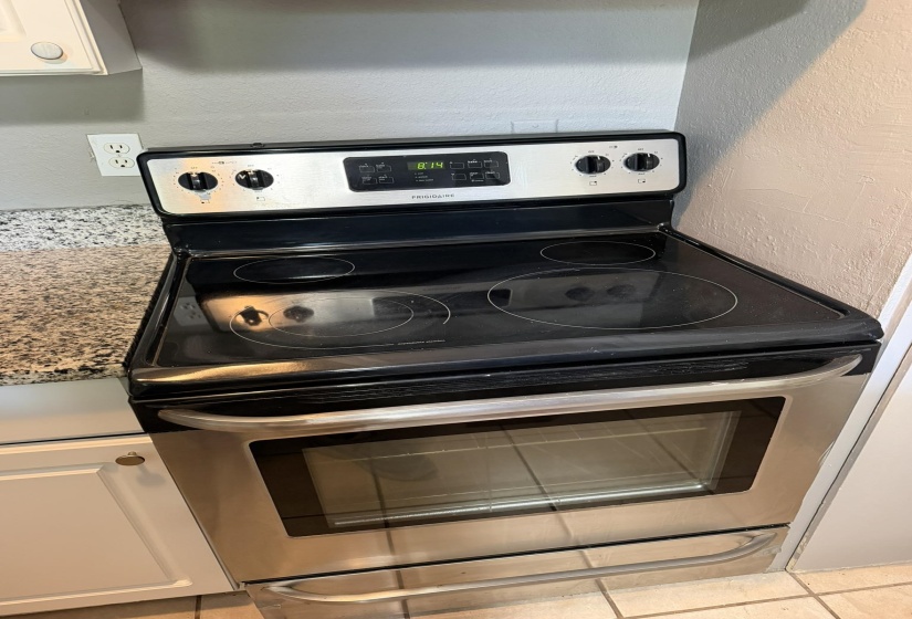 Stainless steel range with a glass cooktop and an integrated oven