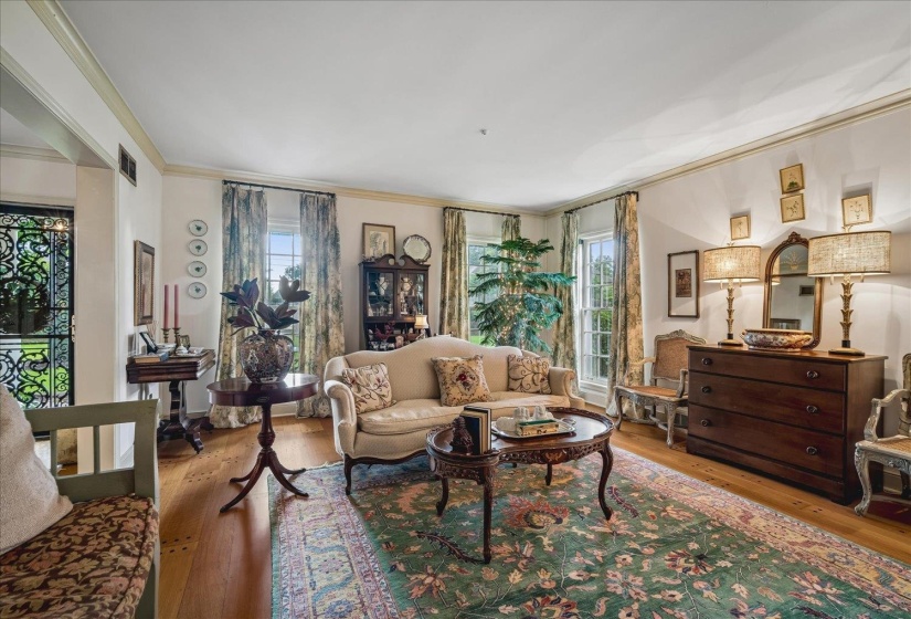 Hardwood flooring and crown molding define this living space