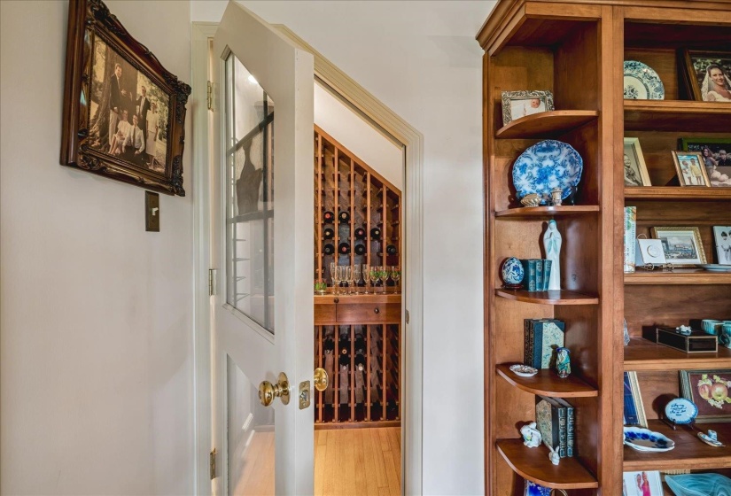 Dedicated wine cellar with extensive wood bottle racking, glass-paneled door, and wood-finish flooring