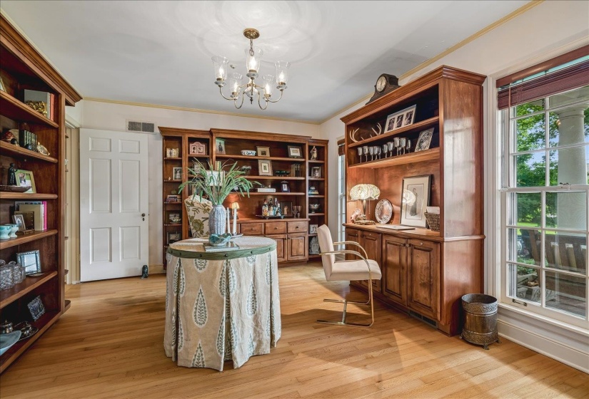 Hardwood flooring throughout featuring extensive built-in cabinetry and shelving