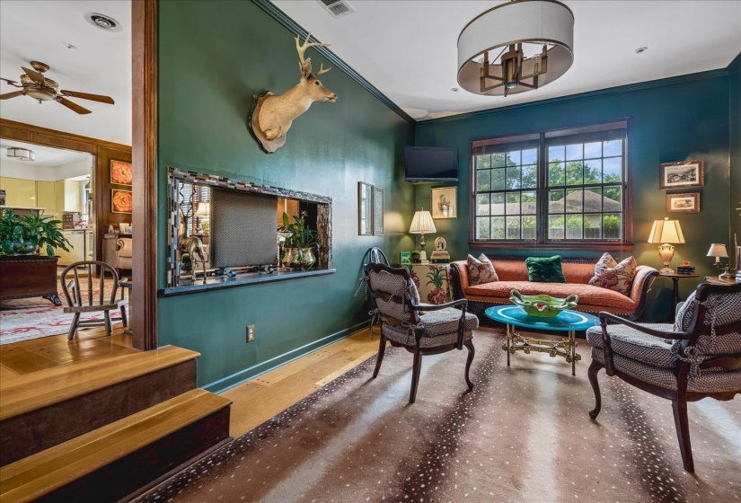 Sunlit interior featuring large windows, wood-finish flooring, and a decorative ceiling light fixture