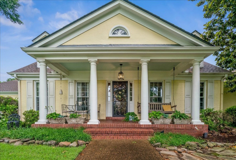 Traditional yellow brick exterior with white architectural columns