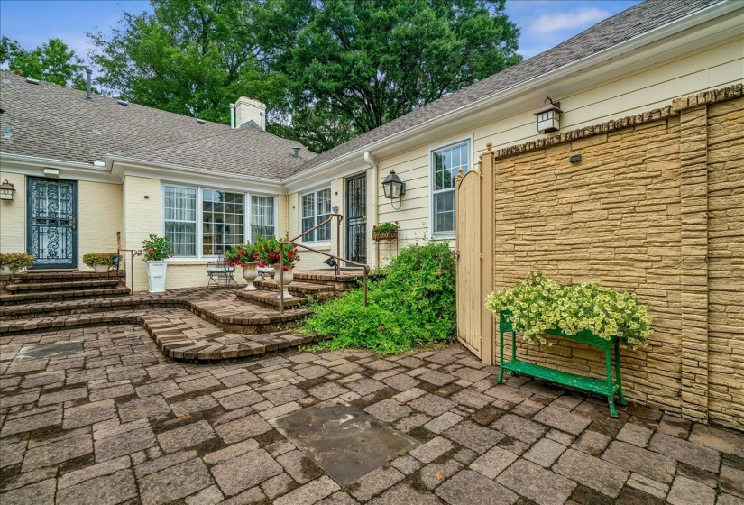 Expansive stone paver patio featuring a meandering brick pathway