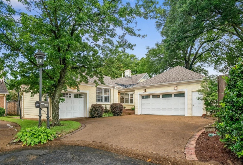Cream-colored exterior featuring two attached garages with white panel doors