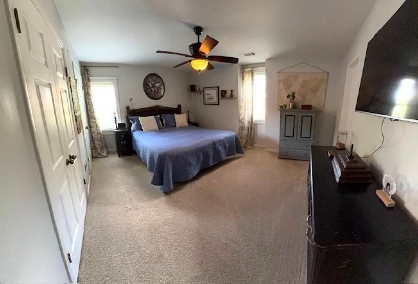 Carpeted room with a ceiling fan light fixture
