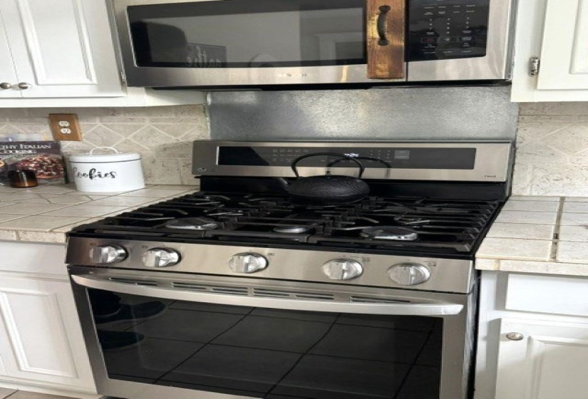 Stainless steel gas range with a coordinating over-the-range microwave