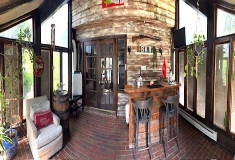 Sunroom featuring an exposed brick floor and expansive windows