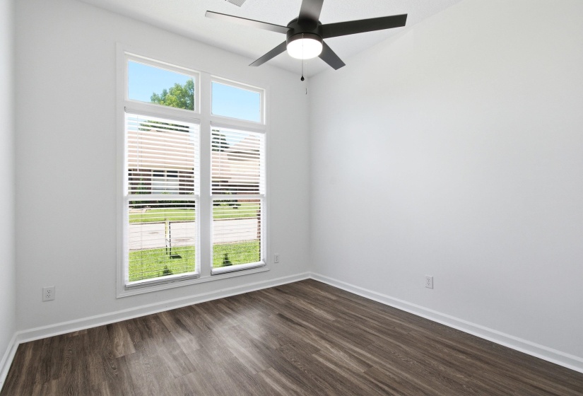 Vaulted ceilings highlight a large window with horizontal blinds and white trim