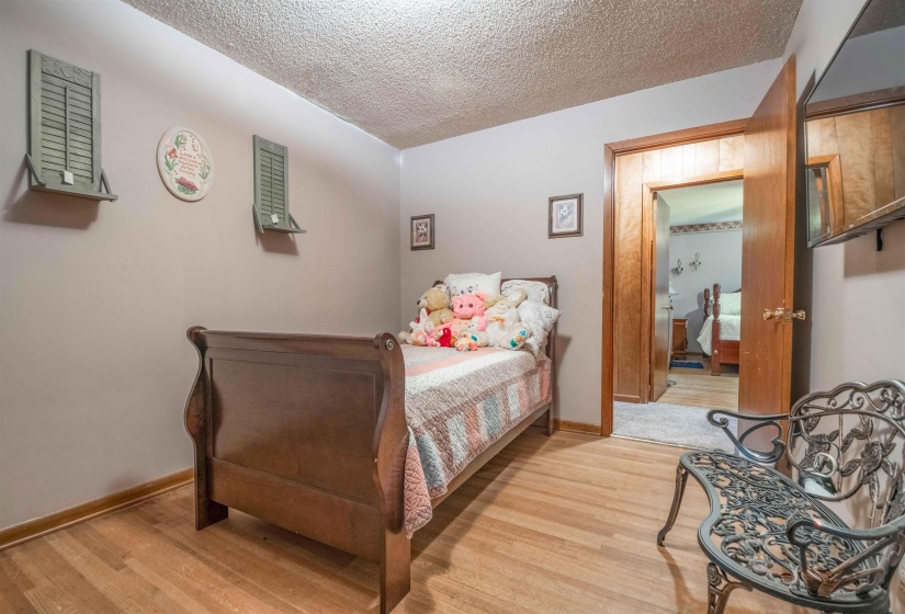 Wood-finish flooring throughout, neutral painted walls, and wood trim around the doorway