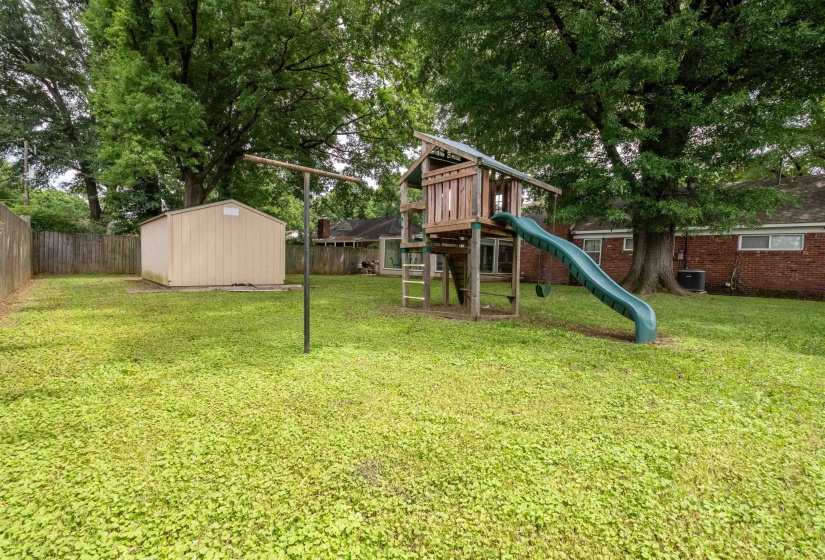 Expansive green lawn with mature trees providing natural canopy
