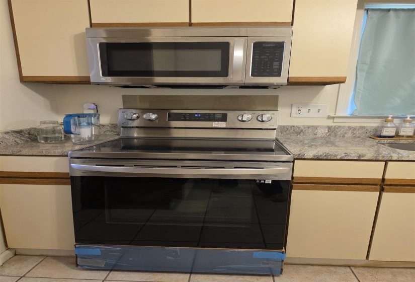 Stainless steel range with a smooth-top surface and a coordinating stainless steel over-the-range microwave
