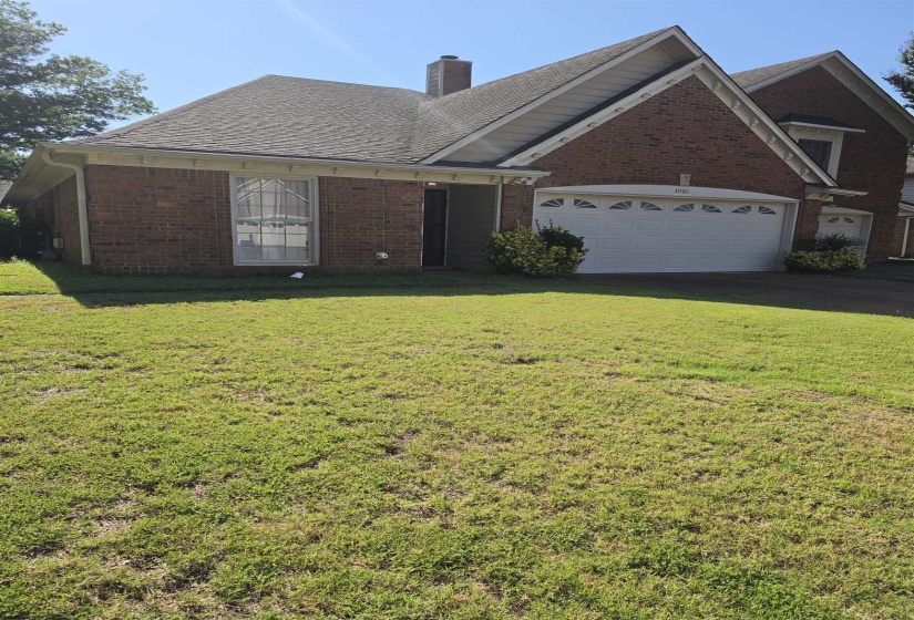 Brick exterior with a prominent two-car garage, multiple gabled rooflines, and a front entry