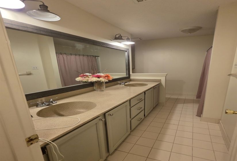 Double vanity featuring integrated sinks, light-toned countertops, and coordinating cabinetry