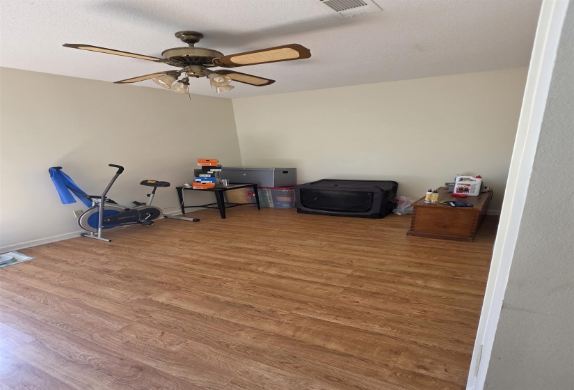 Spacious room featuring wood-finish flooring and neutral wall tones