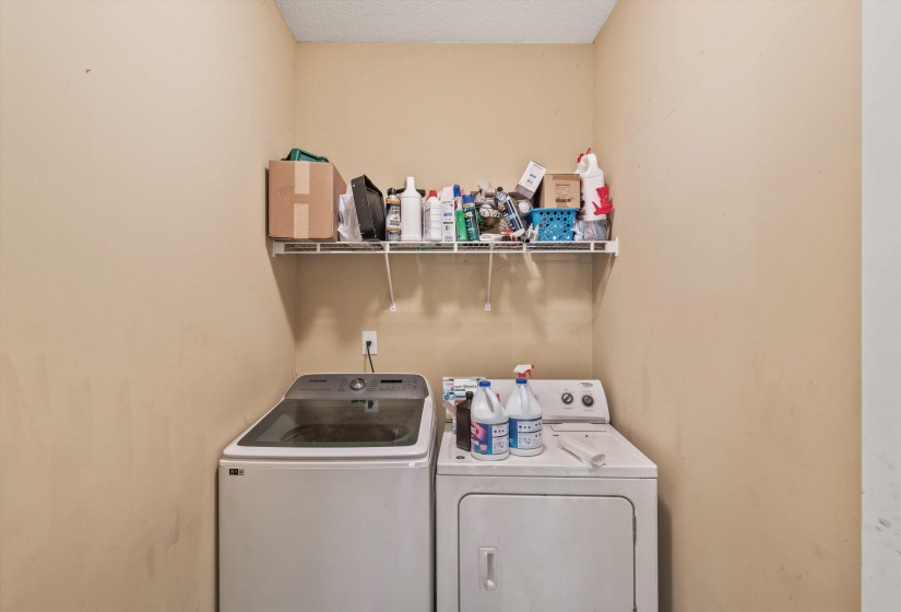 Dedicated laundry area featuring a wire storage shelf