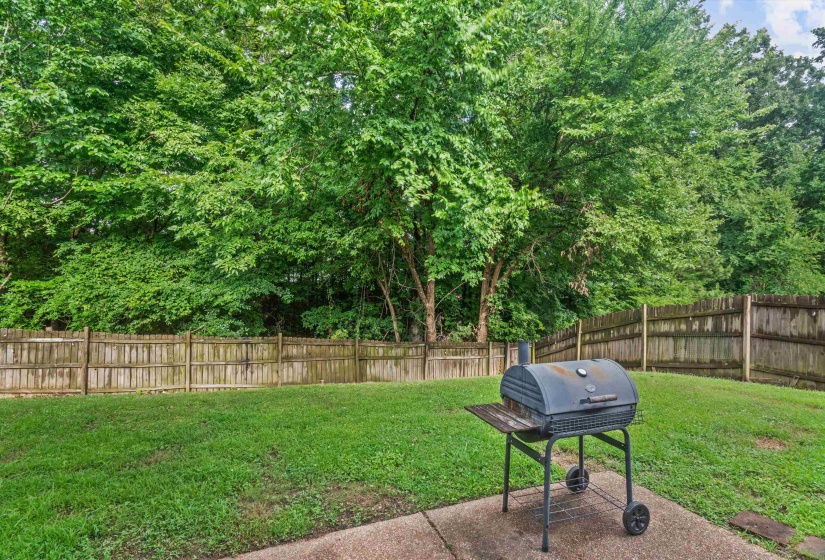Expansive grassy yard with mature trees and wood fencing