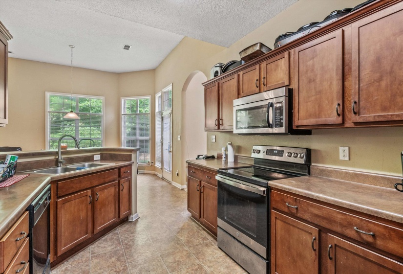 Kitchen featuring wood-finish cabinetry, stainless steel appliances, and a double basin sink