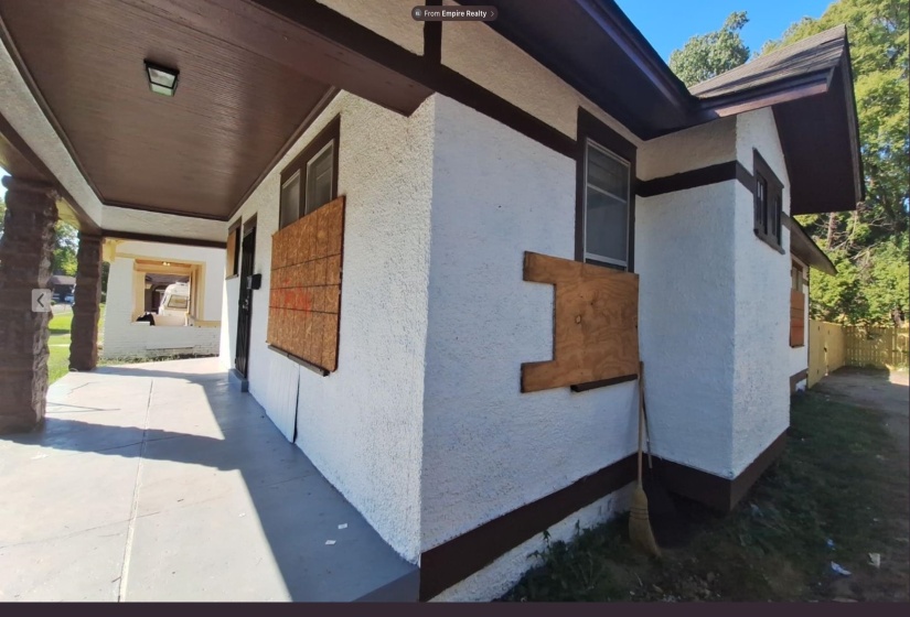 Stucco exterior with dark trim accents and exposed rafter tails