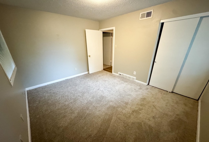 Carpeted room with neutral wall paint and white trim