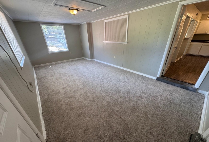 Carpeted room with light-colored panel walls and white trim