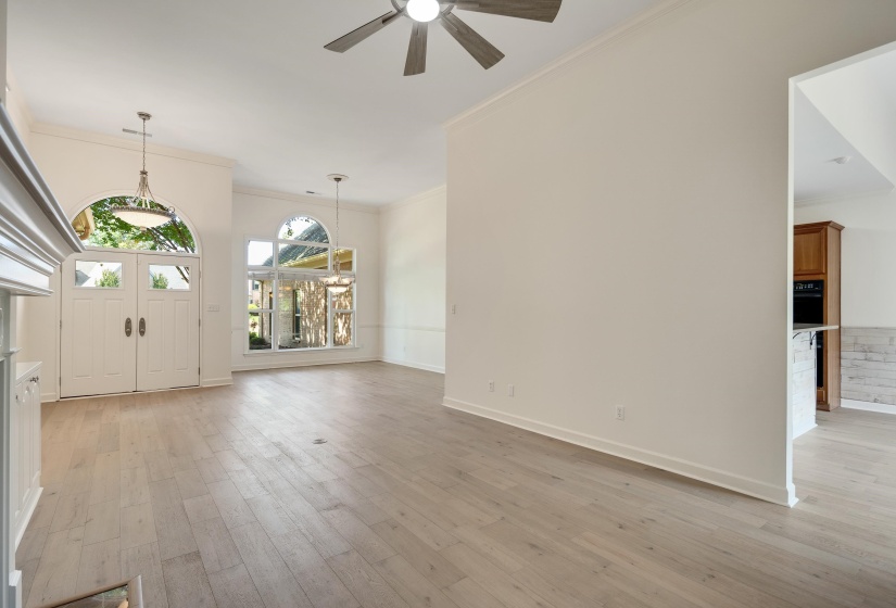 Light wood-finish flooring throughout the main living space with high ceilings
