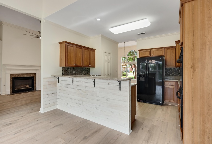 Kitchen features a breakfast bar with white shiplap paneling and a light-toned countertop