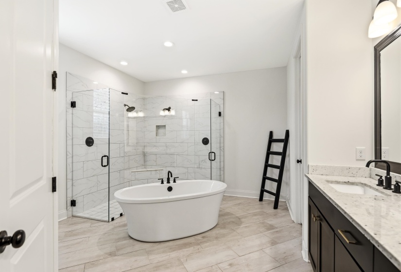 Full bath featuring a shower stall, vanity, and a freestanding tub