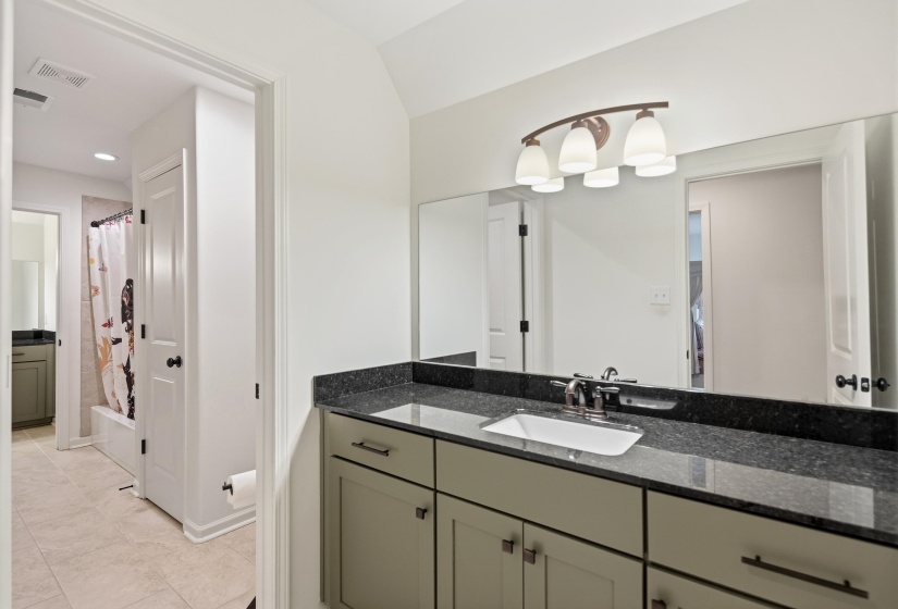 Bathroom featuring vanity and shower / bathtub combination with curtain