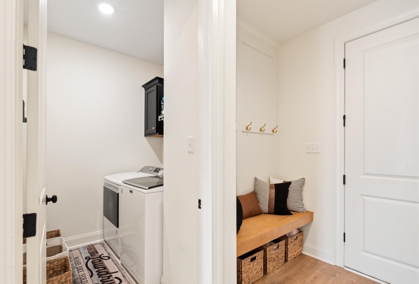 Laundry room featuring light wood-style flooring, washing machine and dryer, cabinet space, and recessed lighting