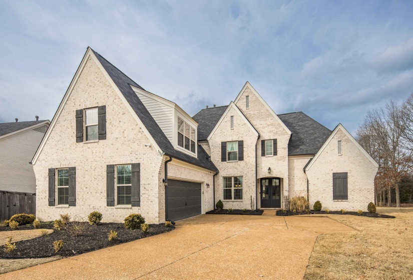 View of front of property featuring brick siding, driveway, a garage, and a shingled roof