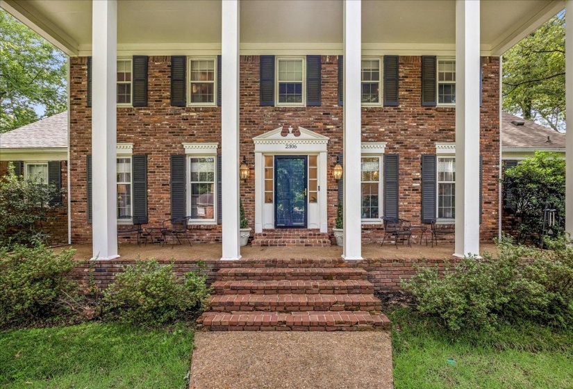Brick facade featuring a columned front porch, brick steps, and a dark entry door with sidelights (do not sell with listing)