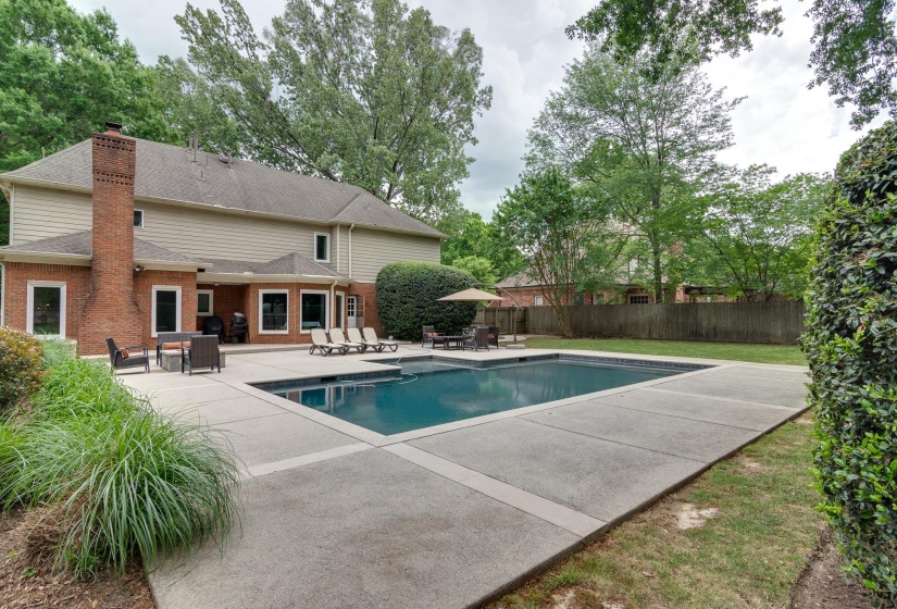 Rectangular swimming pool surrounded by a spacious concrete patio